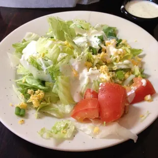 a plate of salad with tomatoes and lettuce