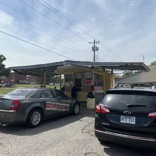 two cars parked in front of a food truck