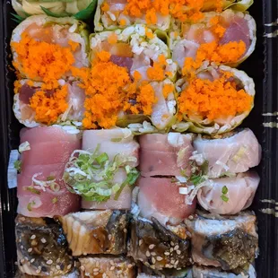 a tray of sushi and vegetables