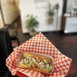 a hand holding a hot dog