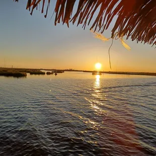 Beautiful sunset framed by the tiki-esque roof of the boat