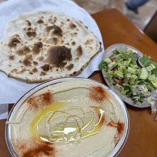 a plate of hummus and a bowl of salad