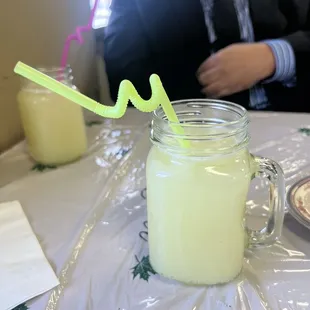 a man sitting at a table with a glass of lemonade
