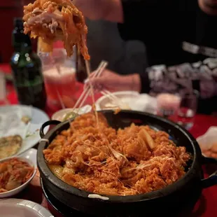 a person holding a fork over a dish of food