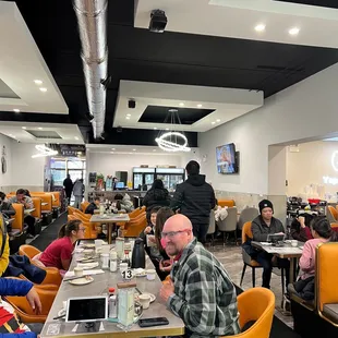 people sitting at tables in a restaurant