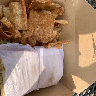 a sandwich and chips in a box
