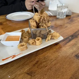 a plate of fried squids and dipping sauce