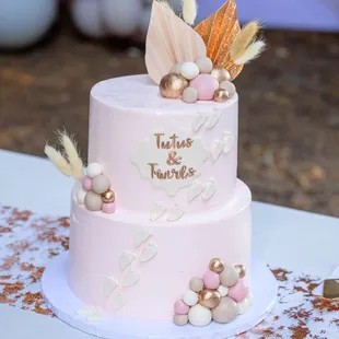 a pink cake with feathers on top