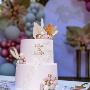 a pink cake decorated with feathers