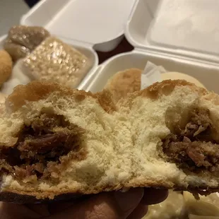 a hand holding a half eaten bun