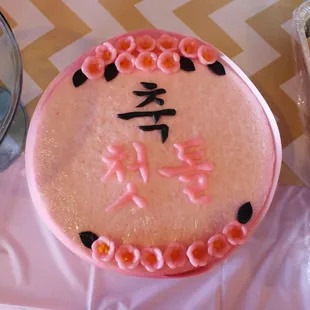 a pink cake with chinese characters on it