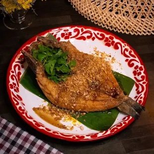 Pla Tod 
Fried branzino whole fish in garlic soy sauce with scallions, cilantro and fried garlic