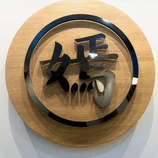a circular wooden sign with chinese characters