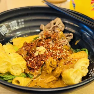 a bowl of food with chopsticks