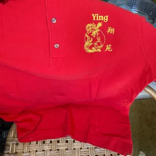 a red polo shirt with a yellow logo