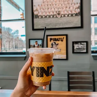 a hand holding a cup of iced coffee