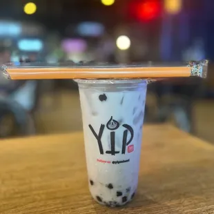 a cup of milk tea with a wooden stick sticking out of it