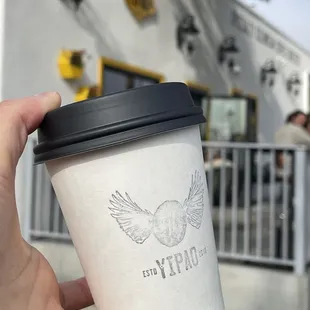 a hand holding a coffee cup