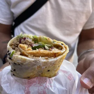 a man holding a burrito in his hand