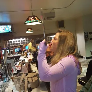 a woman drinking a beer and eating popcorn