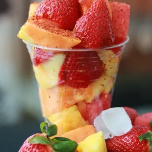 a fruit salad in a plastic cup