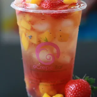 a fruit drink with ice cubes and strawberries