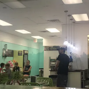 a man in a black shirt standing in front of a counter