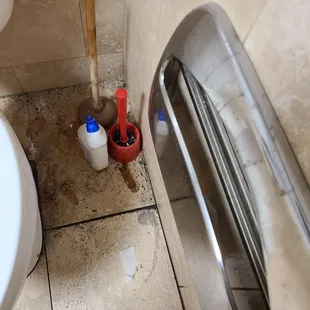 a toilet and trash can in a bathroom