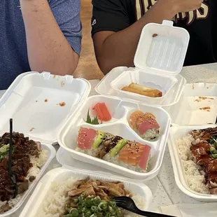 a man sitting at a table with four trays of food