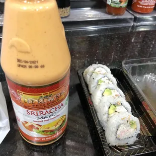 a sushi roll and a bottle of sauce