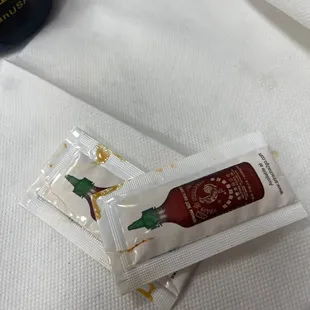 two packets of ketchup sitting on a napkin