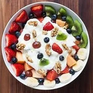 Dig into a refreshing bowl of froyo topped with a colorful array of fruits, beautifully arranged like a pie.