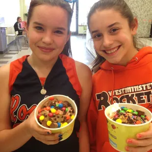 two girls holding bowls of cereal