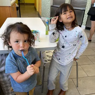 two children brushing their teeth
