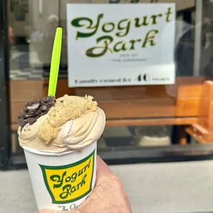 a hand holding a cup of yogurt