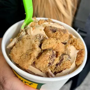 a person holding a cup of ice cream