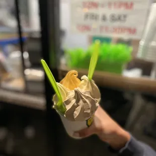 a hand holding a cup of yogurt