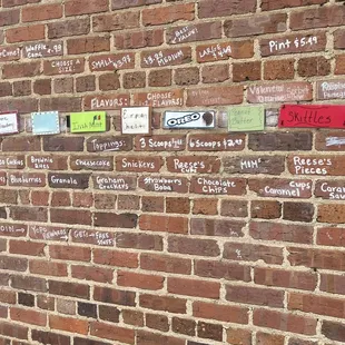 They have the yogurt flavors and toppings listed on the bricks outside!