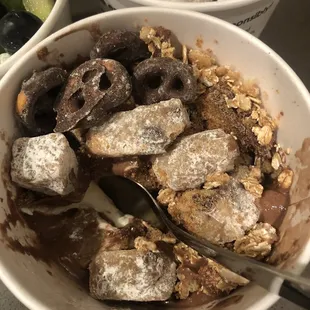 Chocolate/vanilla foyo swirl with chocolate covered pretzels, cookie dough, granola, graham cracker crumbs, and Reese&apos;s cups. 10/10