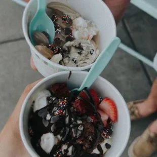 two bowls of yogurt with strawberries, strawberries, and chocolate