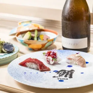 a plate of sushi and a bottle of wine
