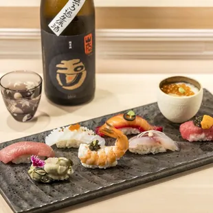 a plate of sushi and a bottle of wine