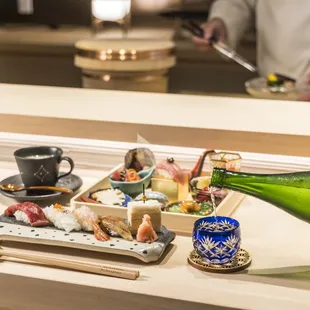a person pouring a bottle of sake