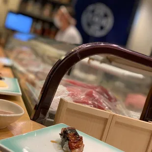 a plate of sushi and a bowl of sauce