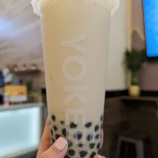 a hand holding a cup of milk tea