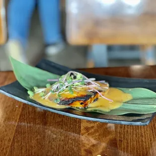 a plate of ramen on a banana leaf