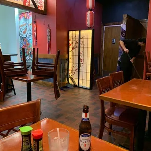 a restaurant with tables, chairs, and a person taking a picture