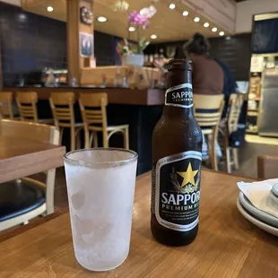 a bottle of sappo beer and a glass of water