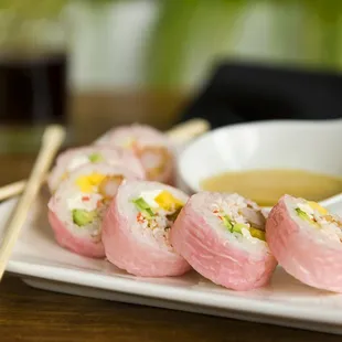 a plate of sushi with chopsticks