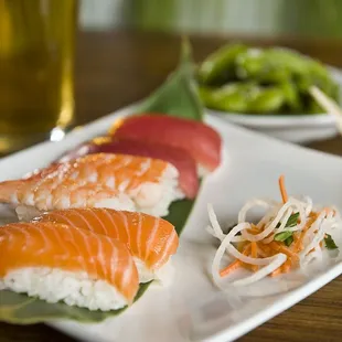 a plate of sushi and a glass of beer